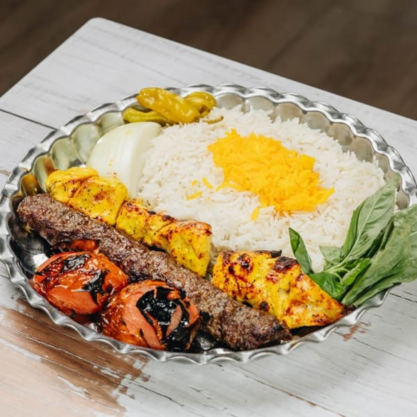 MidEast Eats' platter with rice, chicken and beef kebabs, grilled tomatoes, and fresh herbs.