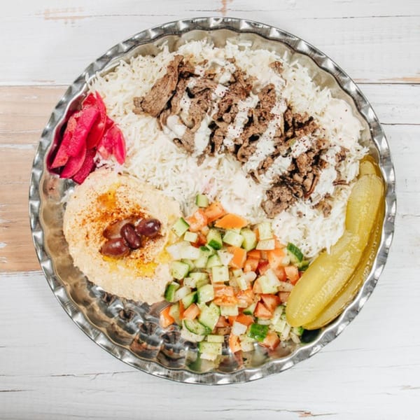 MidEast Eats' Middle Eastern platter with shawarma, rice, hummus, salad, pickled turnip, and a pickle.