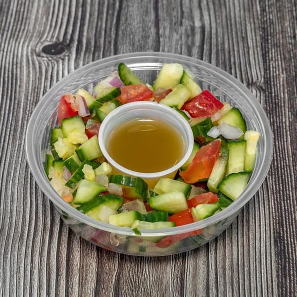 MidEast Eats' fresh cucumber, tomato, and onion salad with dressing in a clear plastic container.
